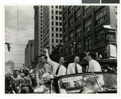 Photograph of Howard Hughes waving to crowds in a parade, Houston, Texas, July 30, 1938