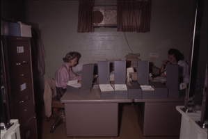 Color view of two women sharing an office area.
