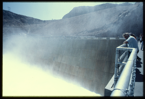 A man watches water flowing down the Arizona spillway, looking northeast at Hoover Dam, Arizona: photographic slide