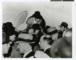 Photograph of Howard Hughes exiting the Lockheed-14 at the Floyd Bennett Airport, New York, July 14, 1938