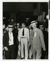 Photograph of Howard Hughes being escorted into the Rico Hotel, Houston, Texas, July 30, 1938