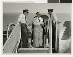 Photograph of crew and passengers leaving a TWA aircraft, circa 1940-1950s
