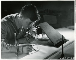 Photograph of Army Air Force officer viewing aerial photographs, circa 1940s-1950s