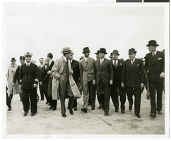 Photograph of Howard Hughes walking with several men, July 1938