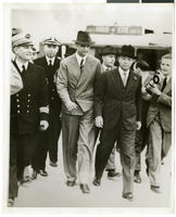 Photograph of Howard Hughes walking with several men in France, July 1938