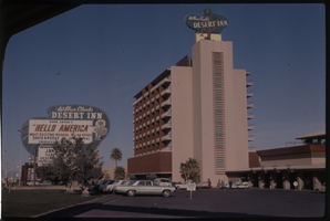 Color view of Wilbur Clark's Desert Inn Hotel. The marquee features Donn Arden's "Hello America" musical, and Davis & Reese.