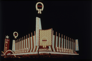 Color view of Binion's Horsehoe at night. A neon sign for The Mint is visible in the background.