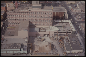 Color aerial view of the Fremont Hotel under construction. The Mint is visible in the background.