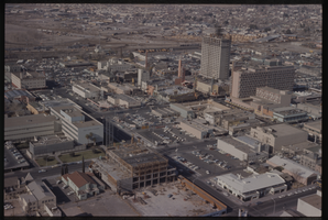 Color aerial view of Downtown Las Vegas. Binion's Horseshoe is under construction. The Mint, Lucky, and the Fremont Hotel are also visible.