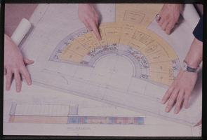 Color photograph of colored blueprints; including "West Elevation" of a building