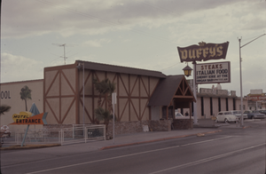 Color view of Duffy's Steak and Italian food restaurant. A bowling alley is visible in the background.