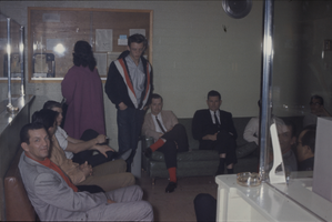 Color view of several people gathered in a reception area.