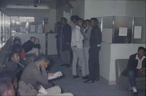 Color view of several people gathered in a reception area.