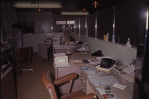 Color view of two people in a shared office area.