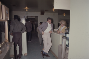 Color view of several people in a service counter area.