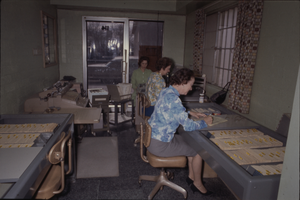 Color view of three women in a shared office area.