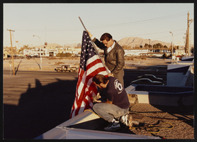 Photographs of Baseball game rally for the Persian Gulf War soldiers; Jim Arnold mounts American flag on union hall, Culinary Union, Las Vegas (Nev.), 1990s (folder 1 of 1)
