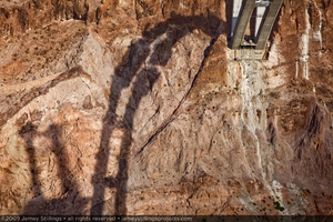 Photograph of a shadow cast upon a canyon wall from the arch of the Mike O'Callaghan-Pat Tillman Memorial Bridge, Arizona border, July 1, 2009