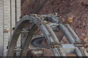 Photograph of workers arriving via highline crane and manbasket to start their shift during construction of the Mike O'Callaghan-Pat Tillman Memorial Bridge, Nevada-Arizona border, September 9, 2009