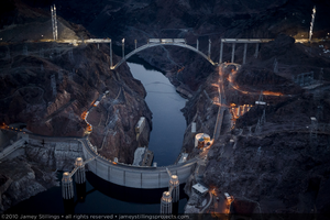 Photograph showing an aerial view of Hoover Dam, Lake Mead, the Colorado River, and the Mike O'Callaghan-Pat Tillman Memorial bridge under construction, Nevada-Arizona border, February 3, 2010