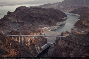 Photograph showing an aerial view of the structurally complete Mike O'Callaghan-Pat Tillman Memorial Bridge, Hoover Dam, and Lake Mead, July 27, 2010