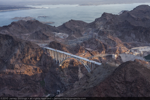 Photograph showing an aerial view of the structurally complete Mike O'Callaghan-Pat Tillman Memorial Bridge, Hoover Dam, and Lake Mead, July 27, 2010
