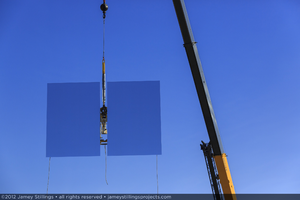 Photograph of heliostat lifted in the air by crane for installation, June 4, 2012