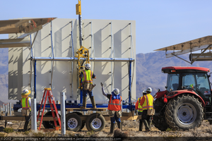 Photograph of workers prepping a heliostat to be removed from trailer by crane, June 4, 2012