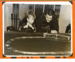 Rex Bell and Rex Bell Jr. playing with model train in game room at Walking Box Ranch: photographic print