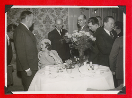 Clara Bow Bell and group of unidentified men at a dinner event in Germany: photographic print