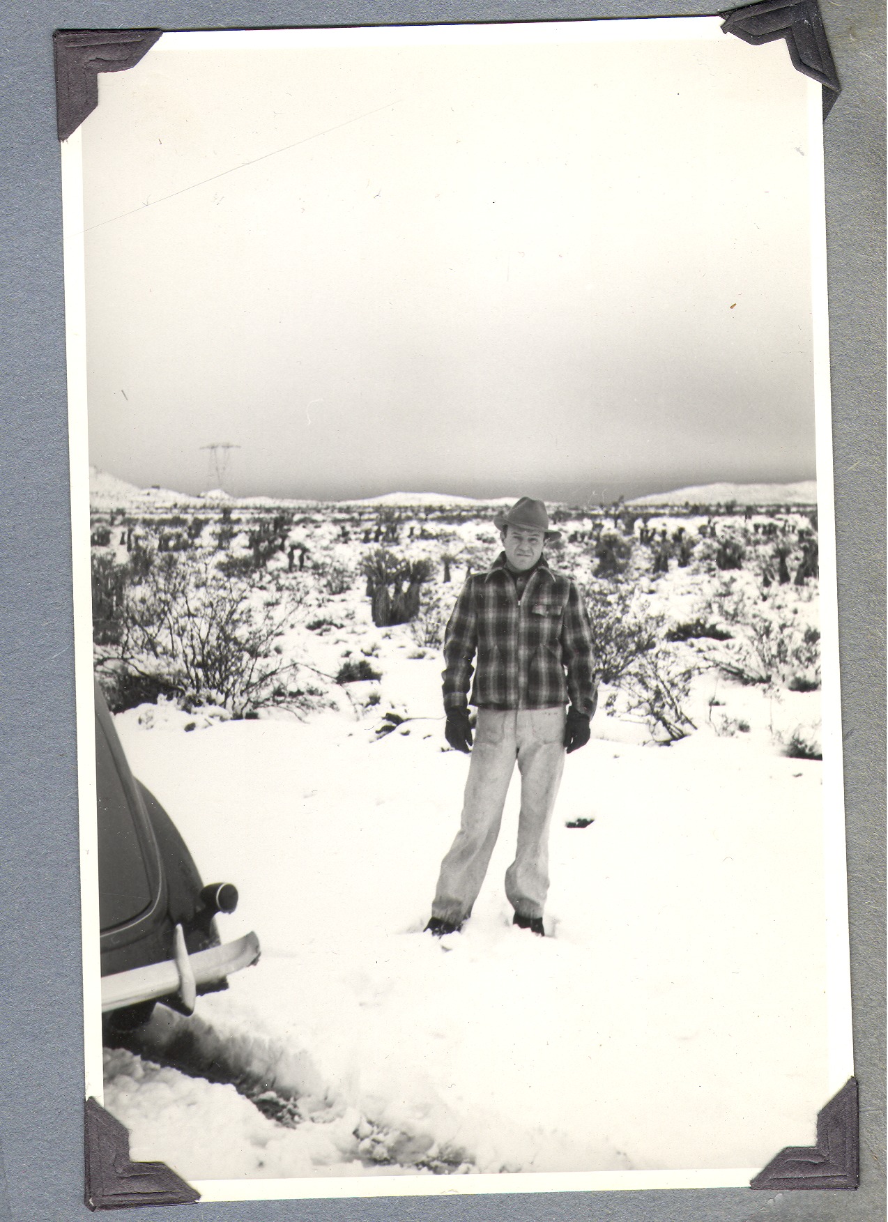 Unidentified man standing in the snow at the ranch: photographic print