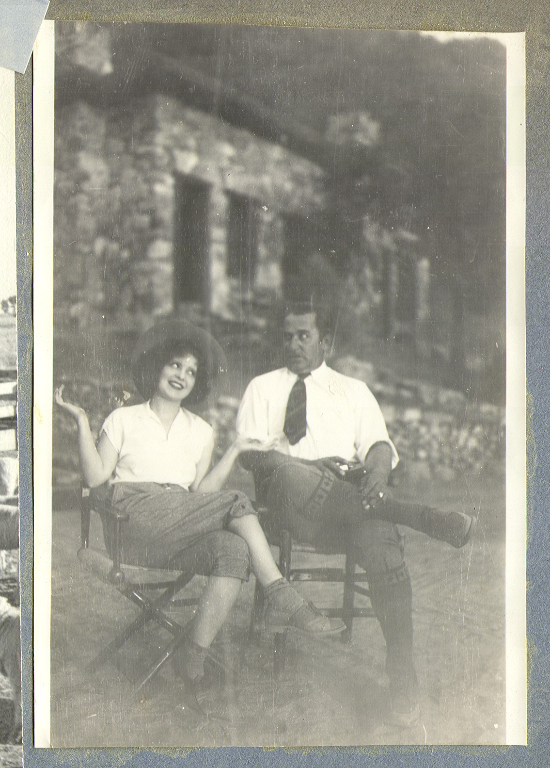 Clara Bow Bell and unidentified man sitting in chairs: photographic print