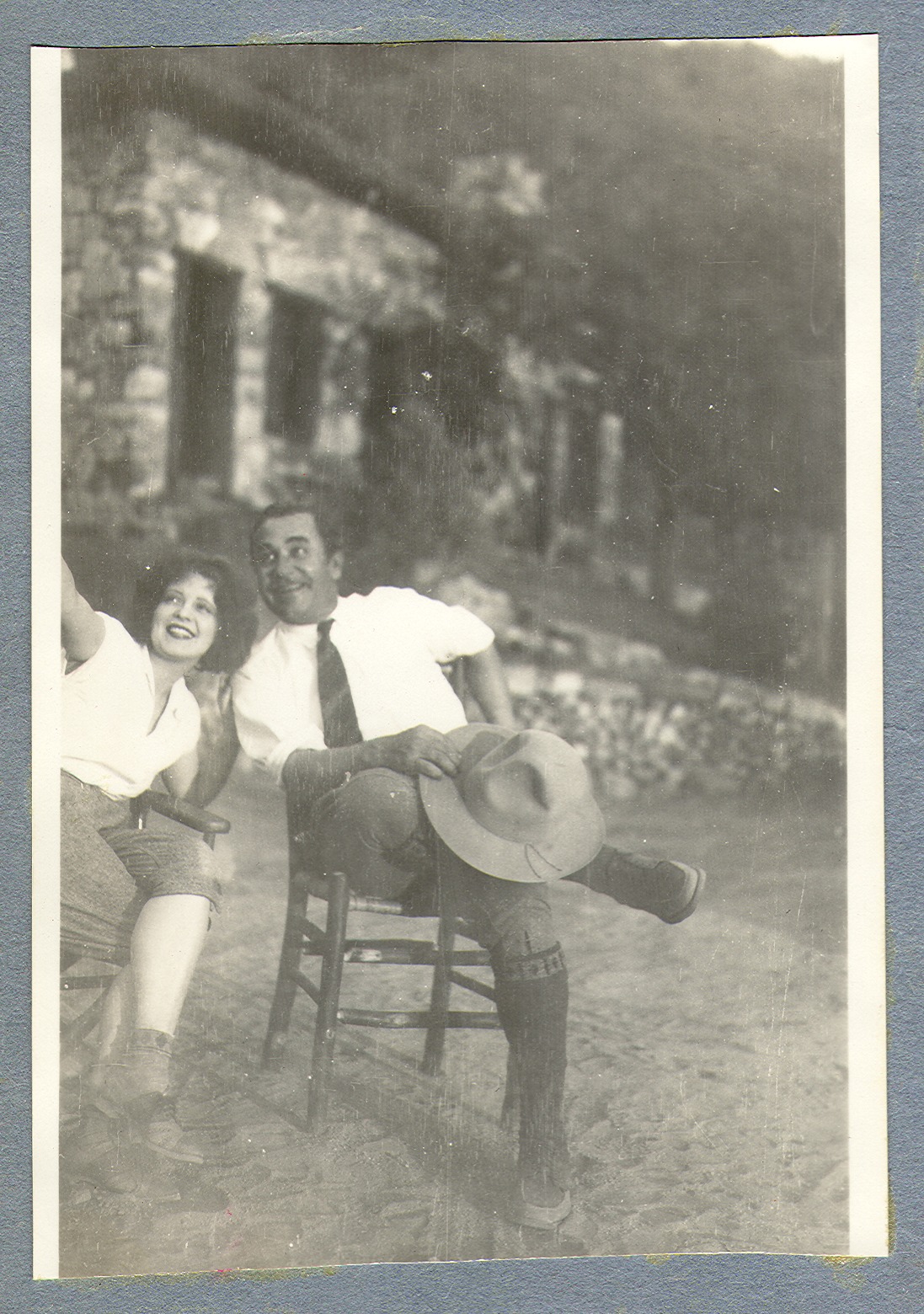 Clara Bow Bell with an unidentified man, seated on the lawn in chairs: photographic print