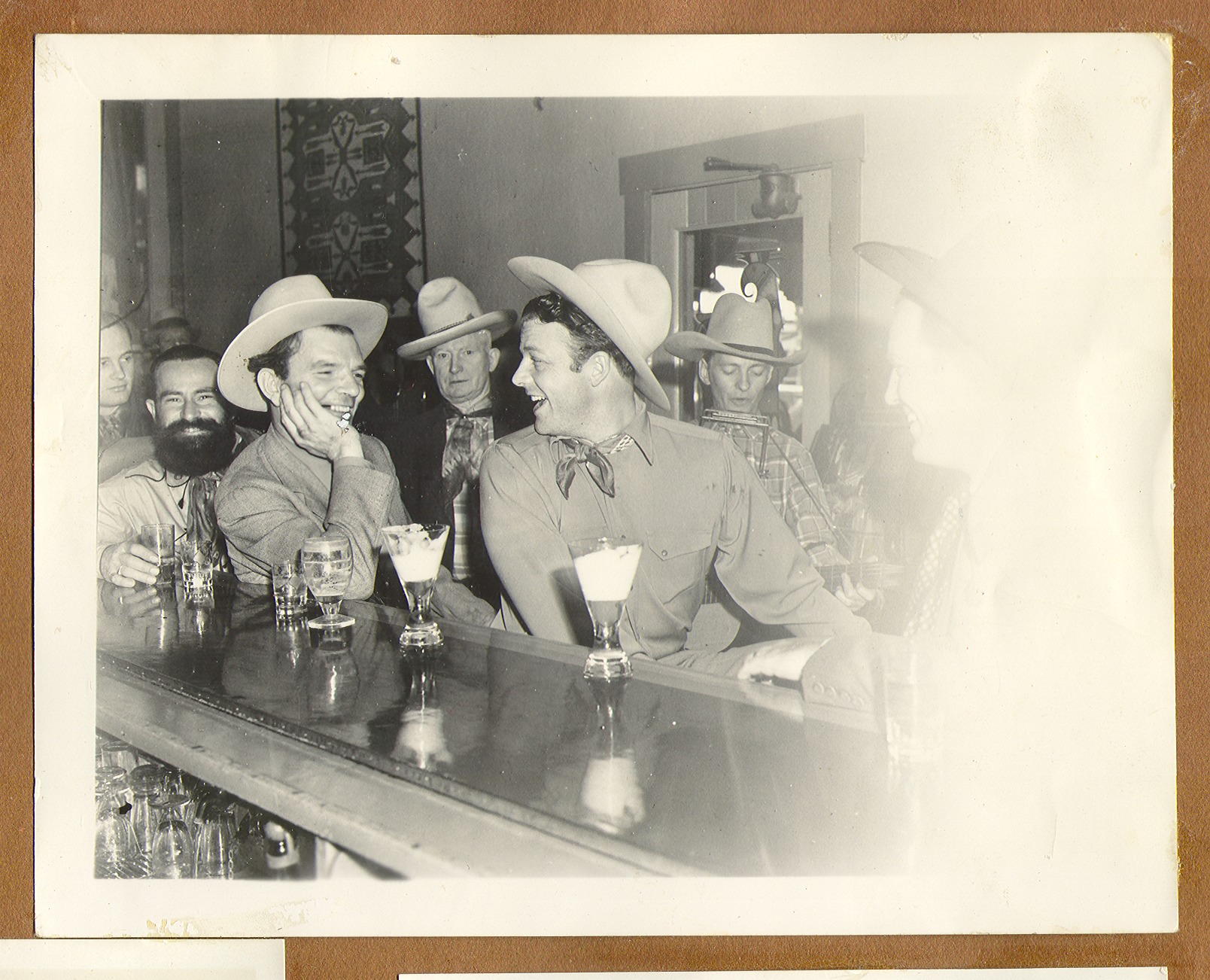 Rex Bell, Curley Fletcher, and  men seated at the bar at the ranch, having drinks: photographic print