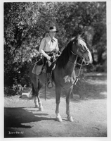 Rex Bell on horseback in costume: photographic print
