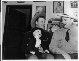 Photograph of Rex Bell (George Francis Beldam) and Bill Froelich with dummy Charlie McCarthy At the bar in the game room in the ranch house at Walking Box Ranch