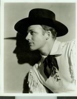 Studio photograph from Universal Studio Pictures Corp. film Battling with Buffalo Bill.  Rex Bell (George Francis Beldam) in costume. Copyright notice on back of image: Photo by Freulich, Universal Pictures Corp.  Also labeled:"Rex Bell who is featured in the Universal serial 'Battling with Buffalo Bill.'"