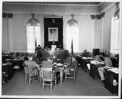 Photograph of a courtroom scene, location unknown, people are unidentified. Copyright notice on the back of image: Nevada State Highway Dept. Photograph