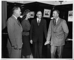 Rex Bell (George Francis Beldam) with Premier Manning, Joan Adams and Provincial Secretary Patrick at an unknown location. Stamped on back: Credit Please, Credit line should be used when this photograph is published.  Ernst of Goertz. Handwritten on back: Premier Manning, Joan Adams and Provincial Secretary Patrick