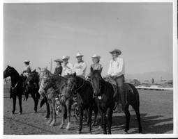 Rex Bell (George Francis Beldam) (third from left) on horseback in a parade with five other people. Stamped on back: Compliments of Lieutenant Governor, Harold J. Powers, Sacramento, California
