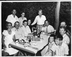 Rex Bell (George Francis Beldam) (second from left) with group at outdoor table.  Written on back is: Homer Bowers, Sen. Bible, State Police Capt. Bud Fairchild, Mrs. Bible and two sons, Don Bowers (back of Rex), Mrs. Homer Bowers (next to Don), Mr and Mrs, Bowers daughter and son-in-law.  Labor Day 1955, Fallon, NV