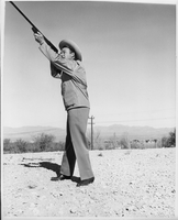 Professional photograph of Rex Bell (George Francis Beldam) holding a rifle. Stamped on back: Ullom Studio. 522 Fremont. Las Vegas, Nevada