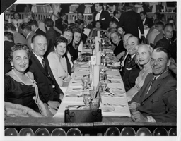 Photograph with Rex Bell (George Francis Beldam) (right) and other unidentified people at a dinner event at an unknown location. Stamped on back: Las Vegas News Bureau, Las Vegas, Nev. - P.O. Box 28, Photographers Don English, Joe Buck, Jerry Abbott