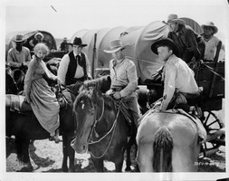 Studio photograph from Universal Studio Pictures Corp. film Battling with Buffalo Bill.  Rex Bell (George Francis Beldam) in costume with gun. Labeled on back: The Universal serial,"Battling with Buffalo Bill" with  Tom Tyler, Lucile Browne, Rex Bell, George Regas, Chief Thunder Bird, and Yakima Canutt