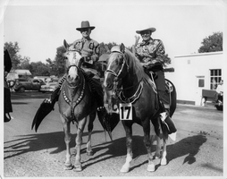 Rex Bell (George Francis Beldam) and Gov. Vail Pittman on horseback in a parade. Helldorado, 1948. Handwritten on back: Gov. Vail Pittman. Helldorado 1948. Stamped on back: Union Pacific Railroad Photo