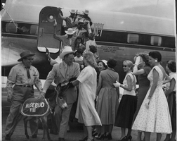 Labeled on back: Miss Carolane Conner greets Rex Bell and other members of Nevada delegation at airport on 6-19-55. Rosebud VIII was present as was 'Ga. Beauties' for the men from Nevada. Stamped on back: This photograph released for publication.  Permission granted for reproduction one time one.  Credit: Charles Pugh, Atlanta Journal-Constitution Photo