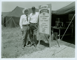Rex Bell (George Francis Beldam) and unidentified man in front of a Boy Scout event sign