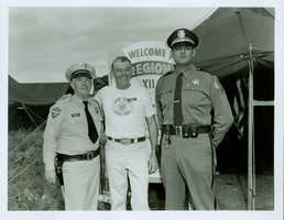 Rex Bell (George Francis Beldam) and two unidentified officers in front of a Boy Scout event sign
