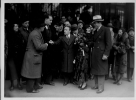 Rex Bell (George Francis Beldam) and Clara Bow while on their trip to Europe with a group of unidentified people at an unknown location. Stamped on back: Wise World Photos, Paris. Handwritten text on back is in French