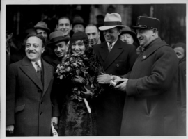 Rex Bell (George Francis Beldam) and Clara Bow while on their trip to Europe with a group of unidentified people at an unknown location. Stamped on back: Wise World Photos, Paris. Handwritten text on back is in French